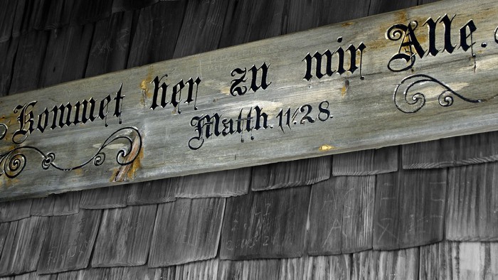 Das Bild zeigt ein hölzernes Schild mit einer Bibelstelle.