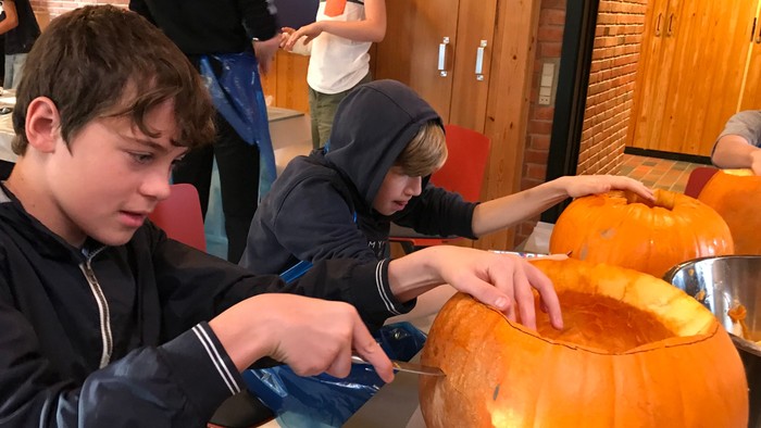 Børnne hugger pumpker i kælder.
