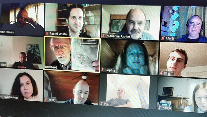 Ein Laptop-Bildschirm zeigt eine Videokonferenz mit mehreren Teilnehmern.