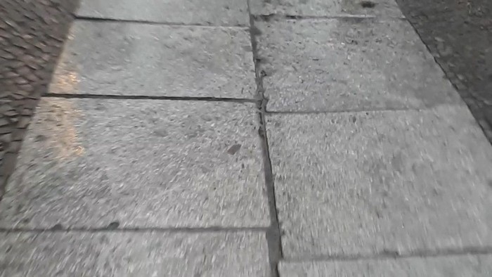 Nasse und glatte Kopfsteinpflasterstraße nach dem Regen.