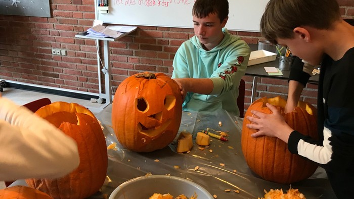 Børn skærer pumpker i klassesalen