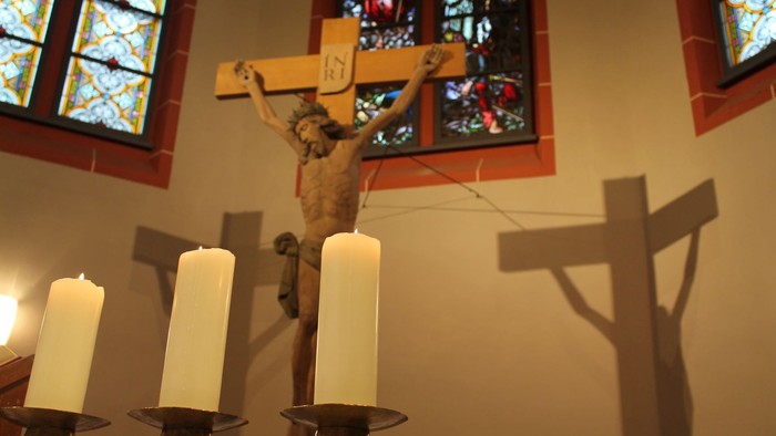 Kreuzigungsszene mit Kerzen und Kirchenfenster