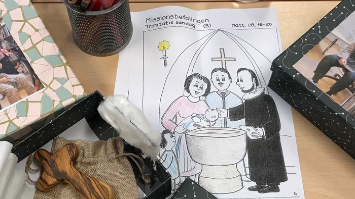 Billeder, blyanter og papir på skrivebord