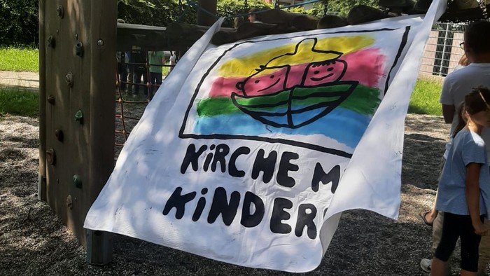 Ein Kind steht neben einem Banner mit der Aufschrift 