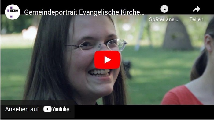 Eine lächelnde Frau mit Brille ist in einem Video-Thumbnail mit dem Titel „Gemeindeportrait Evangelische Kirche“ auf YouTube zu sehen.