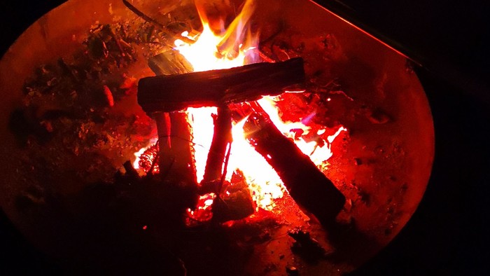 Ein Lagerfeuer brennt in der Dunkelheit
