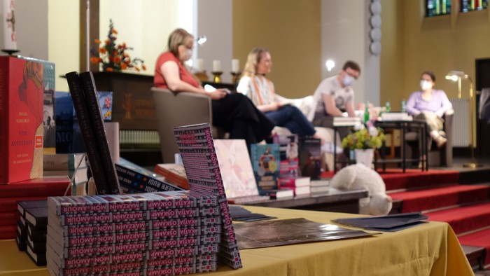 In der Kirche sitzen Menschen vor einem Altar, einer Frau liegt auf dem Boden.