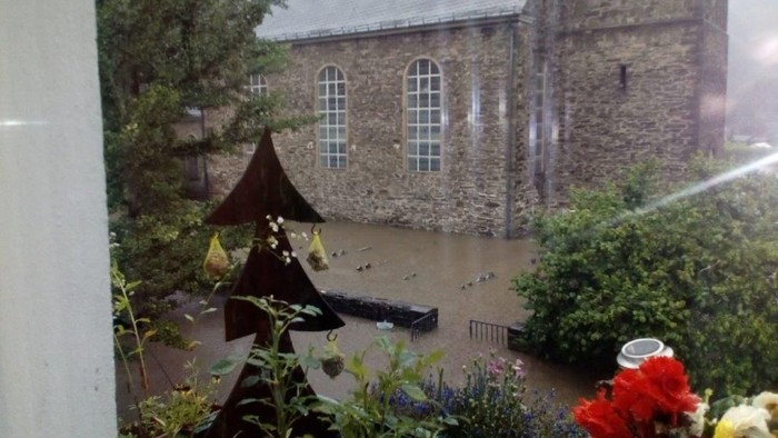 Altes Steinhaus mit spitzen Fenstern und Tauben auf dem Dach.