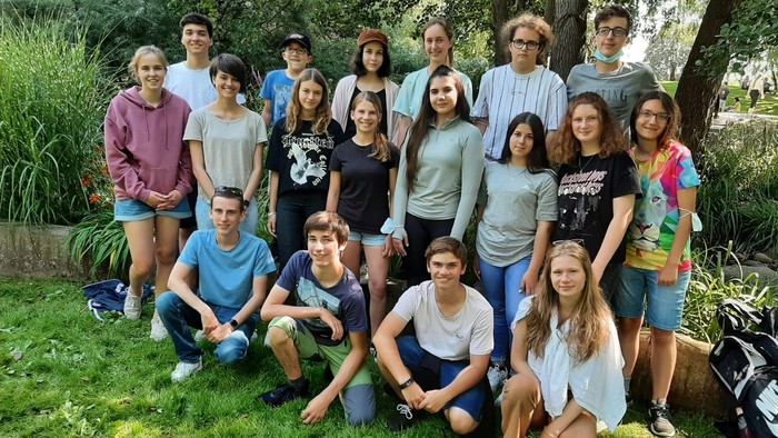 Eine Gruppe von Jugendlichen und Erwachsenen posiert im Freien für ein Gruppenfoto.