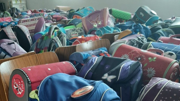 Viele Rucksäcke und Taschen auf Stühlen