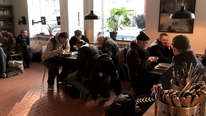 En gruppe af mennesker sidder i et café og spiser.