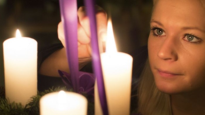 En ung pige ser træt ud mellem lysende lysstaker og violette bælter.
