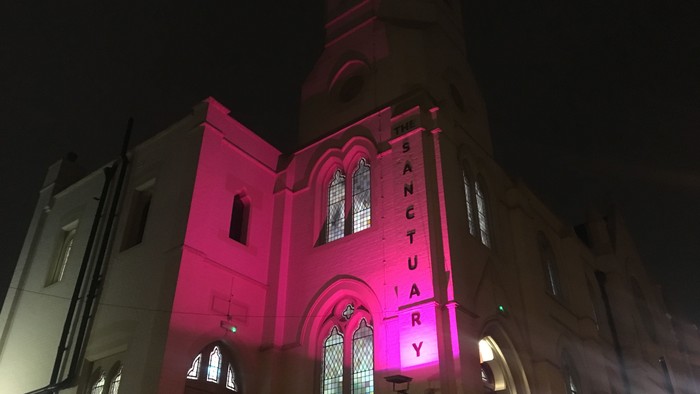 Church illuminated with pink lights at night