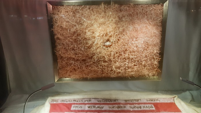 Ein Glasbehälter mit Stroh und einer roten Beschriftung