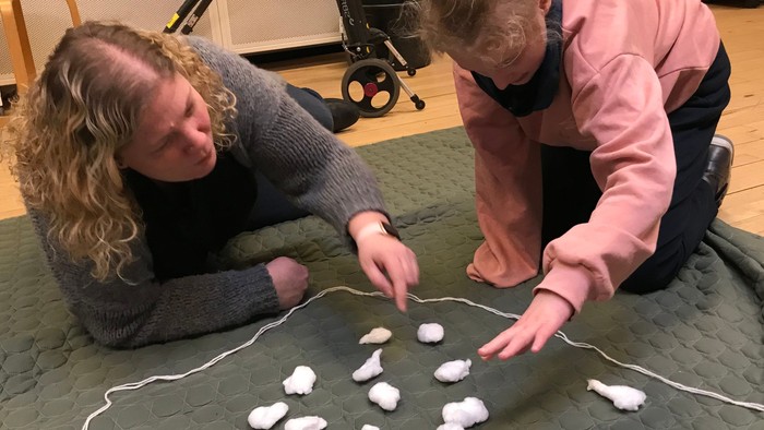 To børn spiller med skærm og skur.
