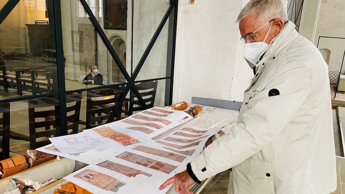 Mann mit Mundschutz schaut sich Bilder an