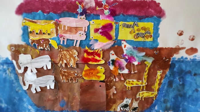 Ein buntes Boot mit Tieren, das auf einem blauen Meer schwimmt