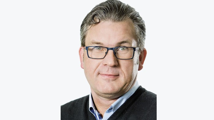 En mand med briller og sort pullover.