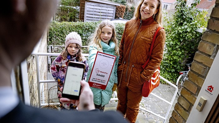 En kvinde og to børn tager selfie på trinbræt med telefon.
