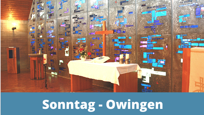 Das Bild zeigt einen Raum mit einem großen Tisch und vielen Monitoren an der Wand.