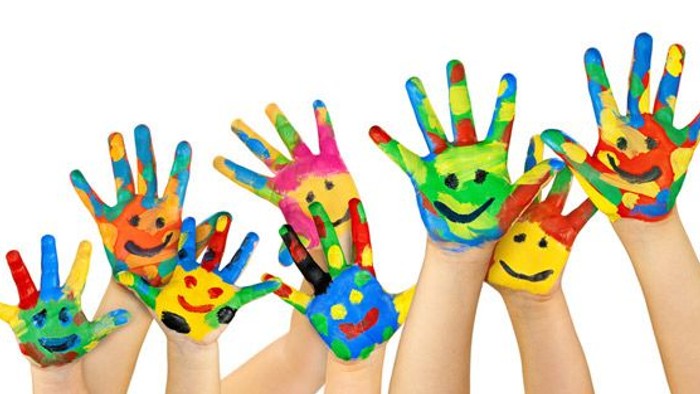 Farbige Kinderhände mit lustigen Gesichtern zeigen nach oben