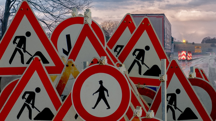 Viele Bauarbeiten-Schildchen auf Brücke bei Dämmerung