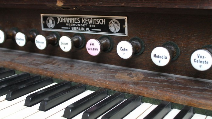 Altes Harmonium mit Aufklebern und schwarzer Tastatur