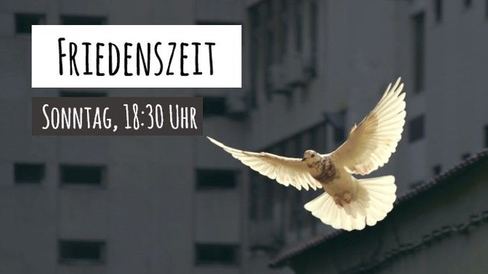Weiße Taube fliegt vor städtischem Hintergrund, Text: "FRIEDENSZEIT Sonntag, 18:30 Uhr"
