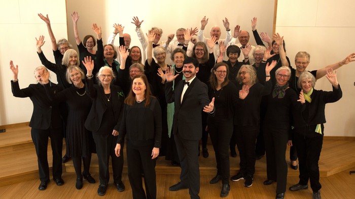 En gruppe af mennesker står sammen med arme op i luften.