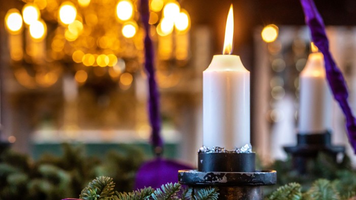 En lysende lyse på en juledekoreret bord.