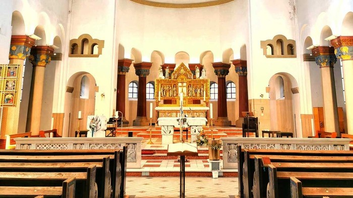 Innenraum einer Kirche mit Kreuz und Kirchenbänken