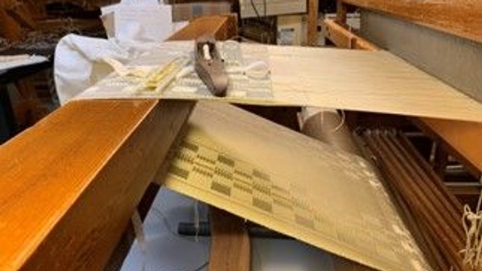 Bænken er belastet med papir, boger og forskellige genstande.