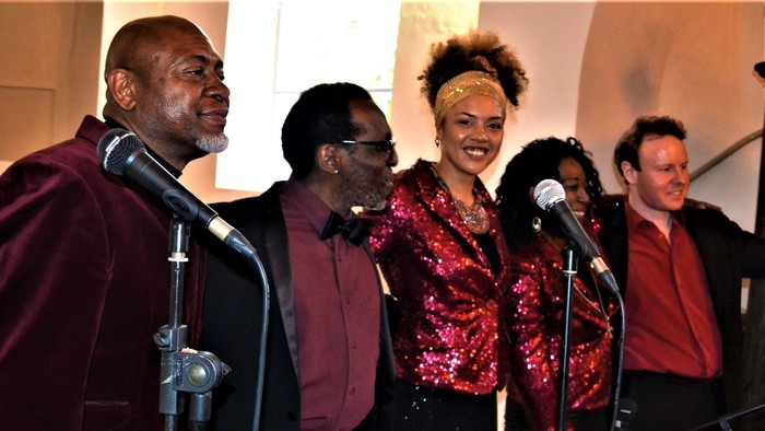 En gruppe af sanger på scenen med mikrofoner