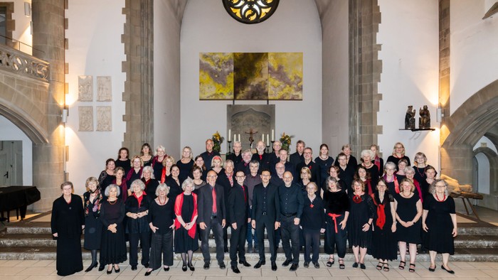 Große Gruppe von Menschen posiert in historischem Gebäude