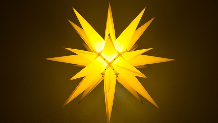 Ein leuchtender gelber Stern vor dunklem Hintergrund