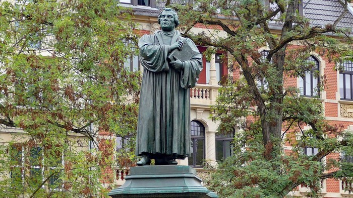 Statue eines Mannes auf einem Sockel vor einem Gebäude