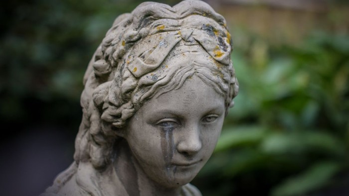 Die Statue einer Frau mit feinen Zügen und geflochtenem Haar.