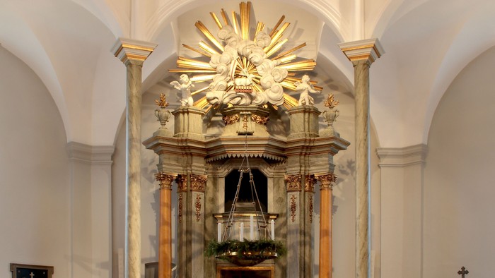 Indre del af kirke med alter og bænke.