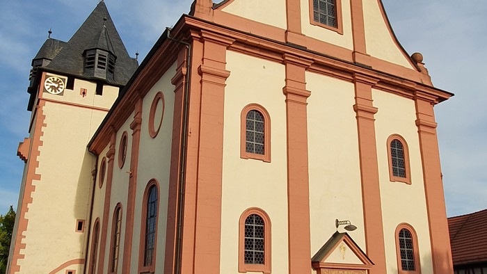 Rosa Kirche mit Turm und mehreren Fenstern.