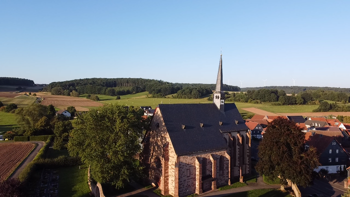 Kirchengebäude in ländlicher Umgebung mit Feldern und Wäldern