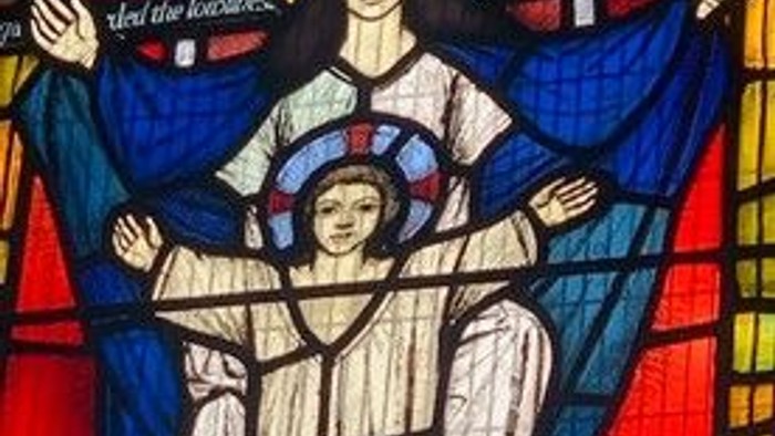 Stained glass window depicting a religious scene with a woman and child.