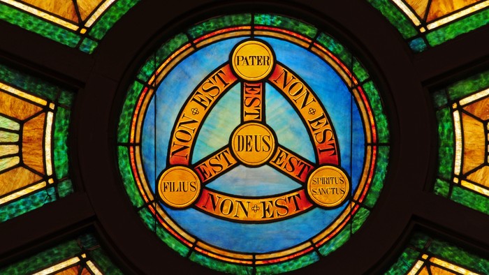 Stained glass window with Latin text and religious symbol