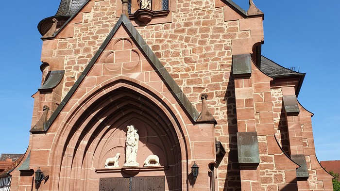 Gothische Kirche mit spitzen Türmen und Kreuz auf dem Dach