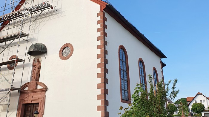 Weiße Kirche mit roter Umrandung und Uhrturm.
