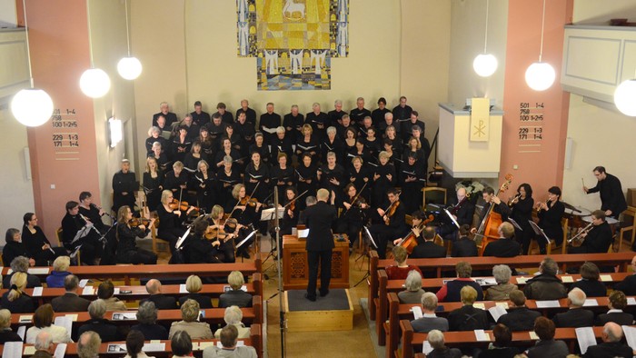 Ein großer Chor und Orchester proben in einer Kirche