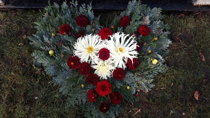 En blomsterarrangement i hjerteform på græsplænen