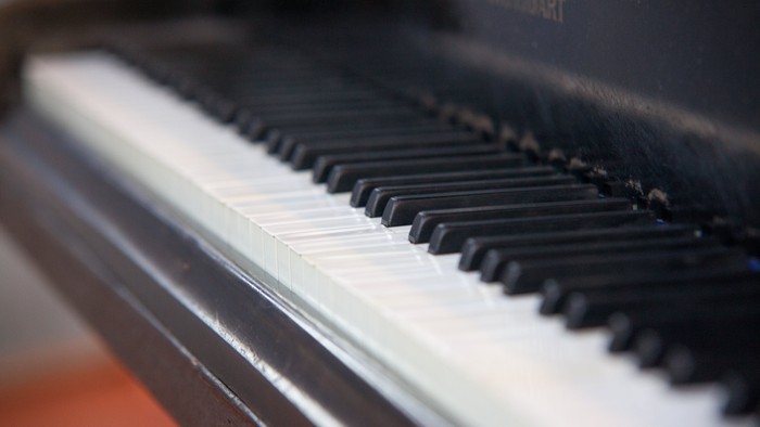 Die Tastatur eines schwarzen Klaviers mit weißen Tasten.