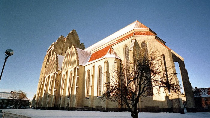 En stor kirke med spisse tårne og røde tag i sneen
