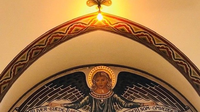 En malet skikkelse af en helgen med latinske indskrifter i en kirkeark