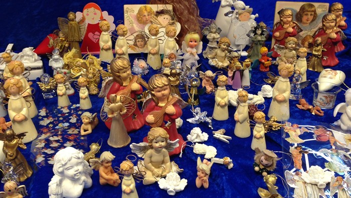 En samling af nisser og englefigurer på blå bæklaede